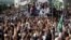 FILE - Supporters of the Tehreek-e-Labbaik Pakistan (TLP) Islamist political party raise their hands as they listen to the speech of their leader during a protest march to condemn a cartoon competition by the Netherlands, in Lahore, Pakistan, Aug. 29, 2018. 