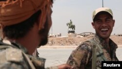 Kurdish fighters from the People's Protection Units (YPG) chat in the Ghwairan neighborhood of Hasaka, Syria, Aug. 22, 2016. U.S. and Russian efforts to protect the local population have allowed civilians to start returning to the city.