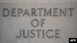 The sign of the U.S. Department of Justice building is seen on its facade, in Washington, Jan. 28, 2019.