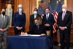 House Speaker Nancy Pelosi of California signs the article of impeachment against President Donald Trump in an engrossment ceremony before transmission to the Senate for trial on Capitol Hill, in Washington, Jan. 13, 2021.