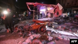 People gather at the site of an air strike on a market in the town of Maarat al-Numan, Syria, on May 21, 2019. 