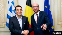 Belgian Prime Minister Charles Michel poses with his Greek counterpart Alexis Tsipras (L) ahead of a meeting in Brussels, Feb. 12, 2015.