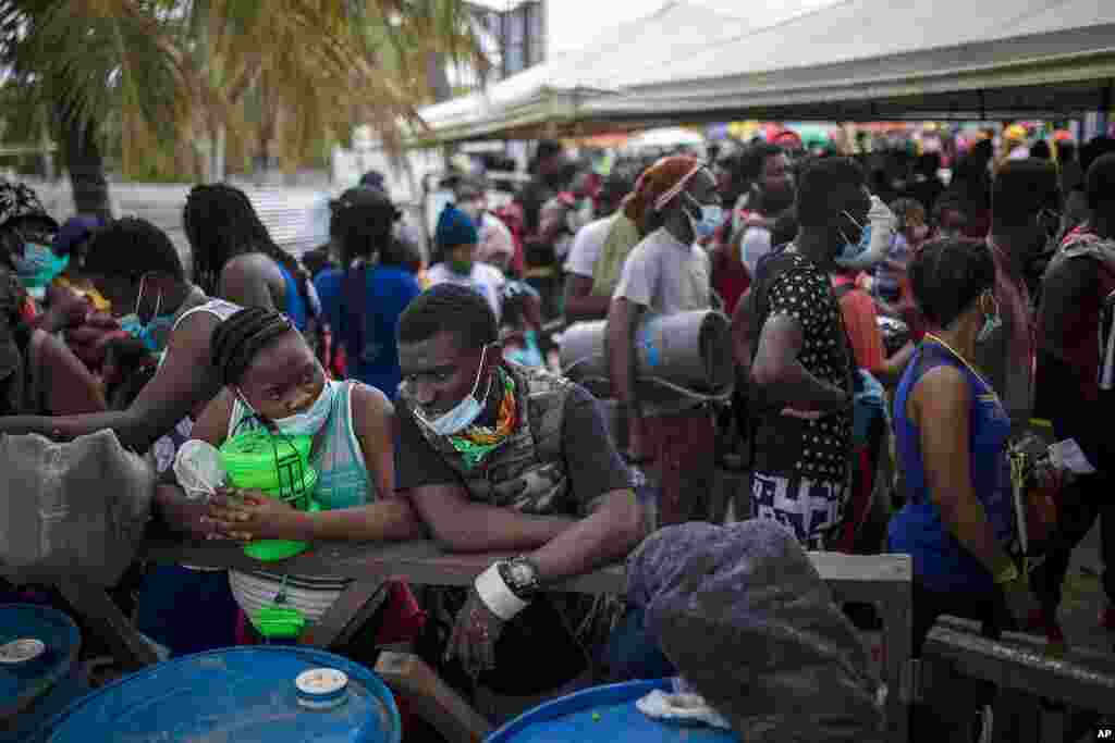Varios migrantes haitianos se reúnen antes de abordar un bote hacia Capurganá, cerca de la frontera con Panamá, el miércoles 28 de julio de 2021, en Necoclí, Colombia. (AP Foto/Iván Valencia)