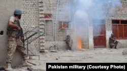 FILE - In an undated photo, Pakistani troops are shown raiding and searching suspected militant hideouts in North Waziristan.