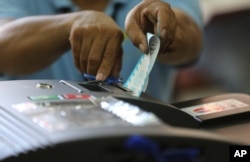 An election worker cuts the receipt from a vote-counting machine at a polling center in suburban San Juan, east of Manila, Philippines on May 9, 2016.