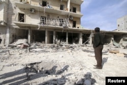 FILE - People inspect the damage after airstrikes by pro-Syrian government forces in the rebel held al-Sakhour neighbourhood of Aleppo, Syria, Feb. 5, 2016.