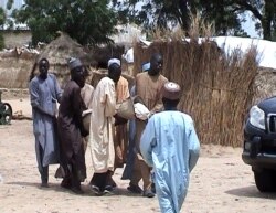 FILE - Men carry a victim after an attack by Boko Haram militants on a funeral in Budu, near Maiduguri, northeast Nigeria, July 28, 2019.