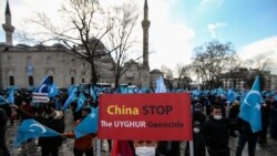A protester from the Uyghur community living in Turkey, holds an anti-China placard during a protest in Istanbul, March 25, against the visit of China's FM Wang Yi to Turkey.