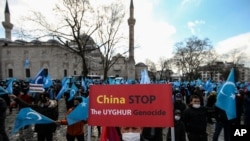 A protester from the Uyghur community living in Turkey, holds an anti-China placard during a protest in Istanbul, March 25, against the visit of China's FM Wang Yi to Turkey. 