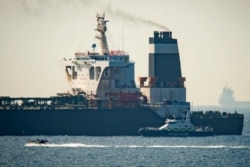 FILE - A Royal Marine patrol vessel is seen beside the intercepted Grace 1 super tanker in the British territory of Gibraltar, July 4, 2019.