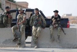 Turkey-backed Syrian rebel fighters stand together near the border town of Tal Abyad, Syria, October 22, 2019. REUTERS/Khalil Ashawi