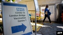 រូបឯកសារ៖ ស្លាកសញ្ញា​បង្ហាញ​ទិសដៅ​សម្រាប់​ចូល​ទៅ​ក្នុង​មជ្ឈមណ្ឌល​ចាក់​វ៉ាក់សាំង​បង្ការ​ជំងឺ​កូវីដ១៩ នៅ​ទីក្រុងឡុងដ៍ ប្រទេស​អង់គ្លេស ថ្ងៃទី៩ ខែសីហា ឆ្នាំ២០២១។ 