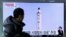 A man watches a TV news program showing a photo published in North Korea's Rodong Sinmun newspaper of North Korea's "Pukguksong-2" missile launch, at Seoul Railway station in Seoul, South Korea, Feb. 13, 2017.