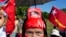 A supporter displays a picture of opposition leader Aung San Suu Kyi stuck in her headband during a campaign rally of the National League for Democracy in Thandwe, Myanmar, Oct. 17, 2015. 