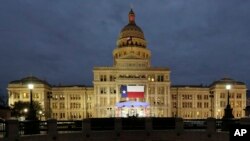 FILE - A large Texas flag hangs from the Texas State Capitol in Austin, Texas, Jan. 14, 2019. Nearly two dozen local governments in the state have been targeted by a coordinated ransomware attack, authorities said. 
