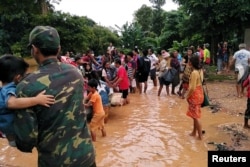Villagers carry their belongings as they evacuate after the Xe-Pian-Xe-Namnoy hydropower dam collapsed in Attapeu province, Laos, July 24, 2018.