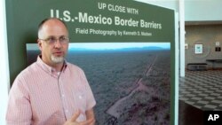 Kenneth Madsen, an Ohio State University-Newark geography professor and border wall expert, discusses his photo exhibit of border wall pictures and maps, "Up Close with U.S.-Mexico Border Barriers," in Newark, Ohio, Sept. 14, 2018.