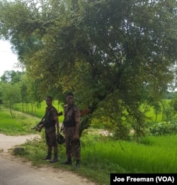 Bangladeshi soldiers stand beside the road leading to Kutupalong refugee camp in Bangladesh, Oct. 6, 2017.