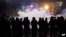 Riot police fire tear gas at supporters of the Shiite Hezbollah and Amal groups in Beirut, Dec. 17, 2019. The groups were angered by a video that showed a man insulting Shiite figures.