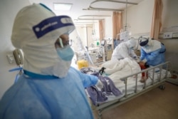 Medical workers in protective suits attend to a patient inside an isolated ward of Wuhan Red Cross Hospital in Wuhan, the epicentre of the novel coronavirus outbreak, in Hubei province, China, Feb. 16, 2020.