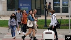 A food delivery robot crosses a street in Ann Arbor, Mich. on Thursday, Oct. 7, 2021. (AP Photo/Carlos Osorio)