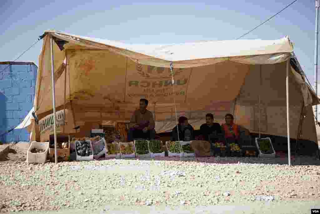 A vegetable vendor has set up shop along the main road that runs through the Za&#39;tari refugee camp. Other makeshift shops sell shoes, clothing and prepared foods. (Y. Weeks/VOA)