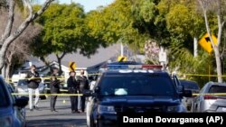 Des enquêteurs de la police se tiennent près de la scène d'une fusillade à Inglewood, en Californie, le dimanche 23 janvier 2022.