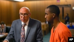 In this Aug. 30, 2017 photo, David Magee, left, a Cuyahoga County public defender, and defendant Hercules Shepherd Jr. attend Shepherd's arraignment in Cleveland. Shepherd's file was scored with risk-assessment software on the first day of the software's