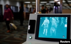 Airline passengers walk past a thermal scanner for body temperature shortly after landing from Singapore at Soekarno-Hatta airport in Jakarta, Indonesia, August 30, 2016.