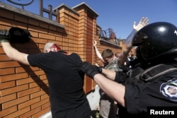 FILE - Interior Ministry members detain anti-gay protesters during the LGBT Equality March in Kyiv, Ukraine, June 6, 2015.
