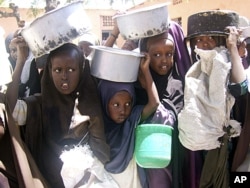 Internally displaced Somali children line up for food aid fat a food distribution center of the World Food Program, in Mogadishu, Somalia, March 15, 2011.
