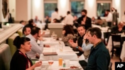 People eating at Gotham restaurant on December 14, 2021, in New York City. (AP Photo/Brittainy Newman)