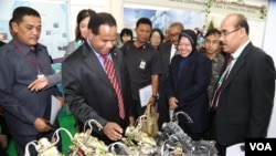 Attendees at the 3R Forum look at toy motorcycles made from recycled parts, Surabaya, Indonesia. (Petrus Riski/VOA)