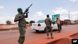 Malian soldiers check a vehicle in the garrison town of Kati, Aug. 18, 2020.