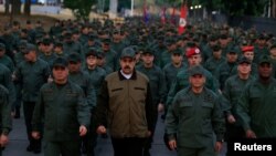 Venezuela's President Nicolas Maduro walks next to Venezuela's Defense Minister Vladimir Padrino Lopez and Remigio Ceballos, Strategic Operational Commander of the Bolivarian National Armed Forces, during a ceremony at a military base in Caracas, Venezuela.