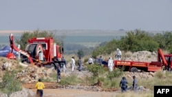 Rescuers and South African Police Service (SAPS) officers carry remains in blue body bags during a recovery operation to retrieve deceased illegal miners from an abandoned gold shaft in Stilfontein, Jan. 13, 2025.