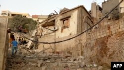 Seorang pria Lebanon berjalan melewati rumah-rumah yang hancur menyusul serangan udara Israel yang ditargetkan di Desa Khiam, Lebanon selatan, dekat perbatasan Lebanon-Israel pada 21 Juni 2024. (Foto: AFP)