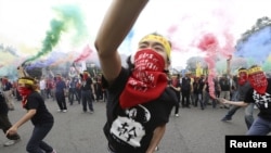 FILE - People throw smoke grenades during recent protests in front of the Presidential Office, Taipei, Taiwan, May 2015.
