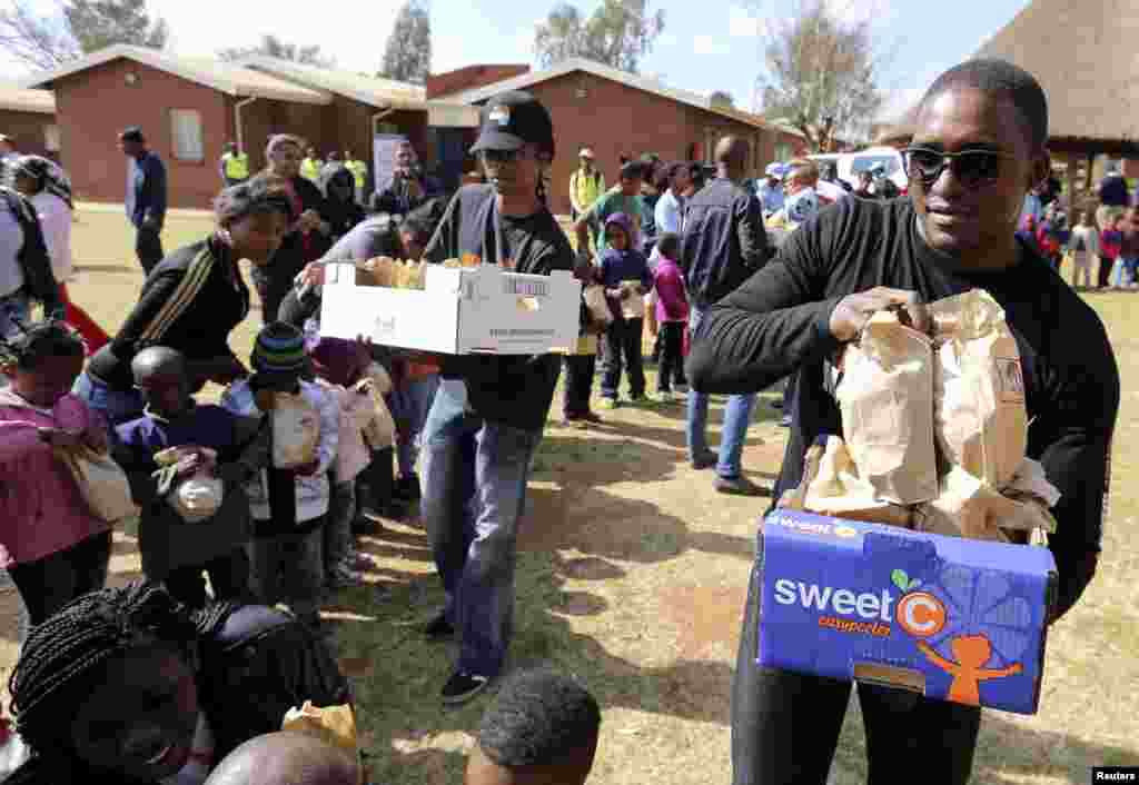 Nelson Mandela&#39;s grandson Zondwa Mandela gives out food parcels as they celebrate Mandela Day with 67 minutes of public service to honour the 67 years Mandela served humanity by first fighting against white-minority rule and then consolidating racial harmony when he was president, at the SOS children&#39;s home in Mamelodi township outside Pretoria July 18, 2013.