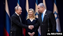 Israeli Prime Minister Benjamin Netanyahu and his wife Sara receive Russian President Vladimir Putin ahead of the World Holocaust Forum at the Yad Vashem memorial centre in Jerusalem, January 23, 2020. Heidi Levine/Pool via REUTERS