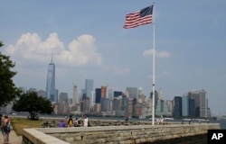 FILE - Tourists view the New York City skyline from Ellis Island, July 29, 2015, in New York. The island, situated in New York harbor, served as an entry point for immigrants to the U.S. from 1892 through 1954.