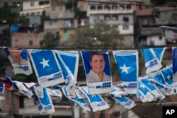 Banners with a portrait of Honduran president and current presidential candidate Juan Orlando Hernandez hang outside a polling station during the general elections in Tegucigalpa, Nov. 26, 2017.