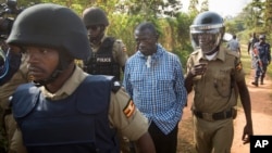FILE - Opposition leader Kizza Besigye (C) is arrested by police outside his home in Kasangati, Uganda, Feb. 22, 2016. His laywer says the government has never been able to secure a single conviction against him.