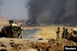 Smoke rises from clashes during the war between Iraqi army and Shi'ite Popular Mobilization Forces (PMF) against the Islamic State militants in al-Ayadiya, northwest of Tal Afar, Iraq, Aug. 28, 2017.