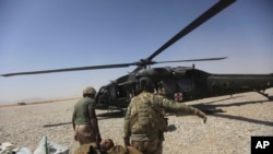 FILE - A U.S. Army medics carry a wounded soldier in Afghanistan's Helmand province Sept. 6, 2011. Two U.S. soldiers were among those killed and two were wounded when they came under enemy fire in Kunduz province, Afghanistan, the U.S. military said Thursday.