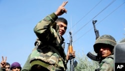 Syrian government soldiers flash the victory sign as they advance in their battle against Syrian rebels, in eastern Ghouta, Syria, in this photo released March 7, 2018, by the Syrian official news agency SANA.