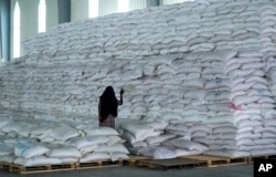 FILE - A worker walks next to a pile of sacks of food earmarked for the Tigray and Afar regions in a warehouse of the World Food Programme (WFP) in Semera, the regional capital for the Afar region, in Semera, Ethiopia, Feb. 21, 2022.