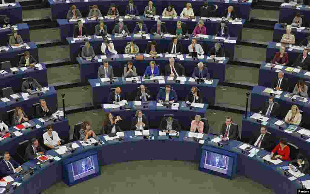 Ukraine's President Petro Poroshenko is seen on TV monitors as he addresses both European and Ukrainian parliaments during a live video conference between Kyiv and Strasbourg ahead of voting by lawmakers in Strasbourg, Sept, 16, 2014. 