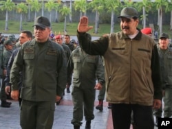 In this photo released by Miraflores Press Office, Venezuela's President Nicolas Maduro, right, accompanied by his Defense Minister Vladimir Padrino Lopez, waves upon his arrival to Fort Tiuna, in Caracas, Venezuela, May 2, 2019.
