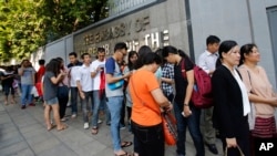 Myanmar people living in Thailand line up for early voting outside Myanmar Embassy in Bangkok, Thailand, Saturday, Oct. 17, 2015.